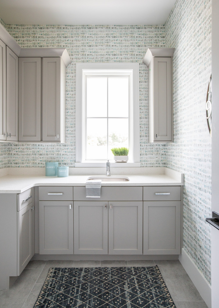 Immagine di una sala lavanderia stile marinaro con lavello sottopiano, ante in stile shaker, ante grigie, pareti multicolore, pavimento grigio e top bianco