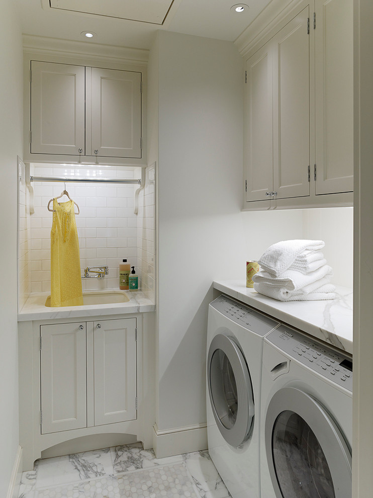 Idee per una sala lavanderia chic con lavello sottopiano, ante in stile shaker, ante bianche, pareti bianche e lavatrice e asciugatrice affiancate