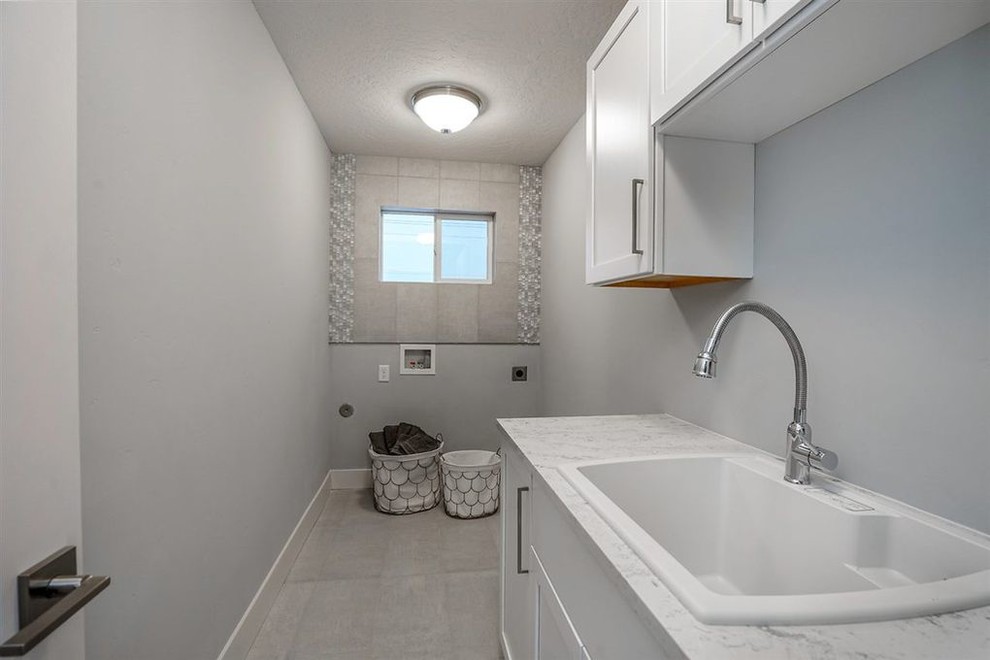 Dedicated laundry room - small modern single-wall ceramic tile and gray floor dedicated laundry room idea in Seattle with a drop-in sink, shaker cabinets, white cabinets, quartz countertops, gray walls and a side-by-side washer/dryer