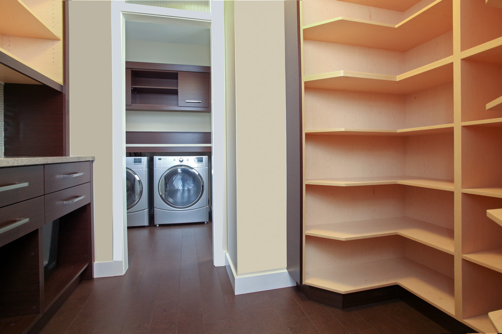 Esempio di una sala lavanderia contemporanea di medie dimensioni con ante lisce, ante in legno scuro, pareti beige, pavimento in legno massello medio e lavatrice e asciugatrice affiancate