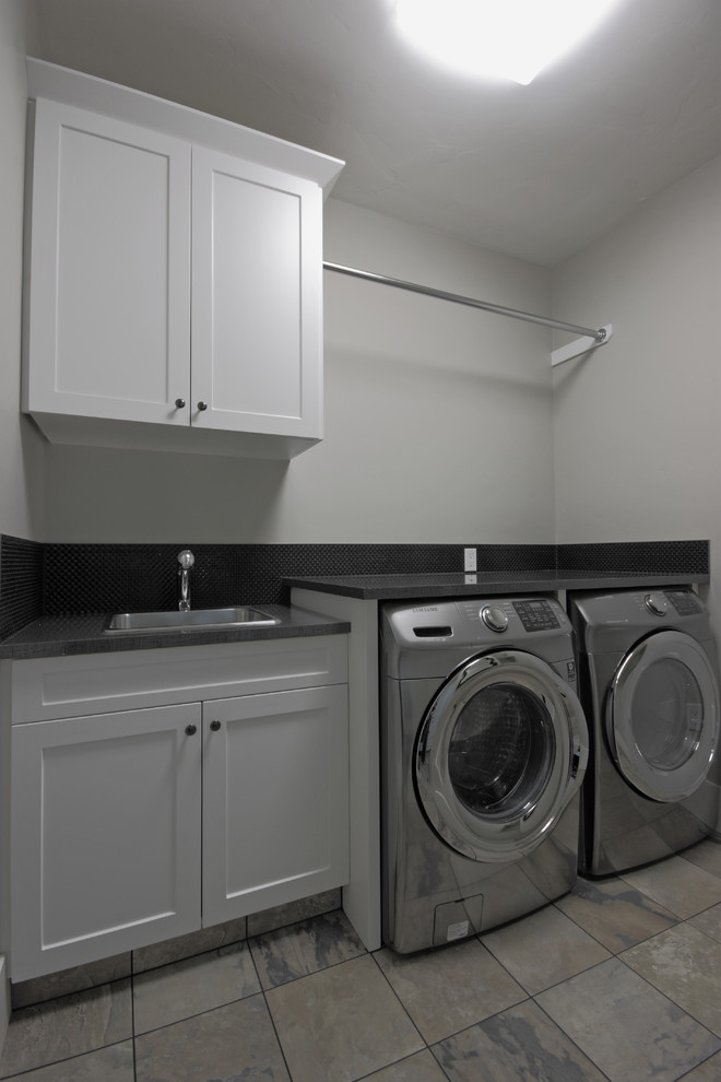 Diseño de lavadero en L actual de tamaño medio con armarios estilo shaker, puertas de armario blancas, encimera de cuarzo compacto y suelo de madera oscura