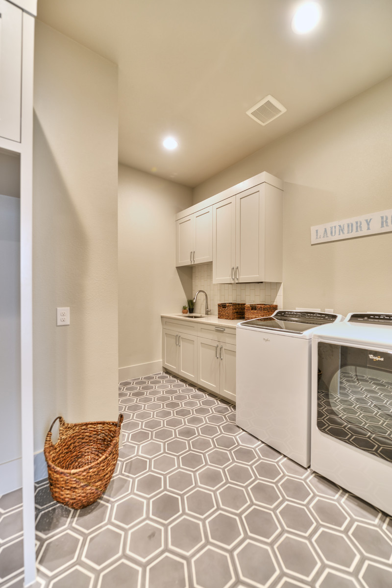 Large classic single-wall separated utility room in Austin with shaker cabinets, white cabinets, beige walls, vinyl flooring, a side by side washer and dryer and grey floors.