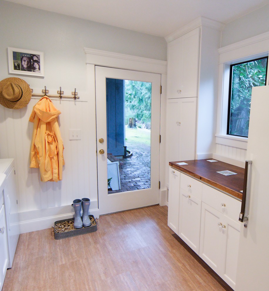 Klassische Waschküche mit Landhausspüle, Schrankfronten im Shaker-Stil, weißen Schränken, Arbeitsplatte aus Holz, blauer Wandfarbe und Vinylboden in Seattle