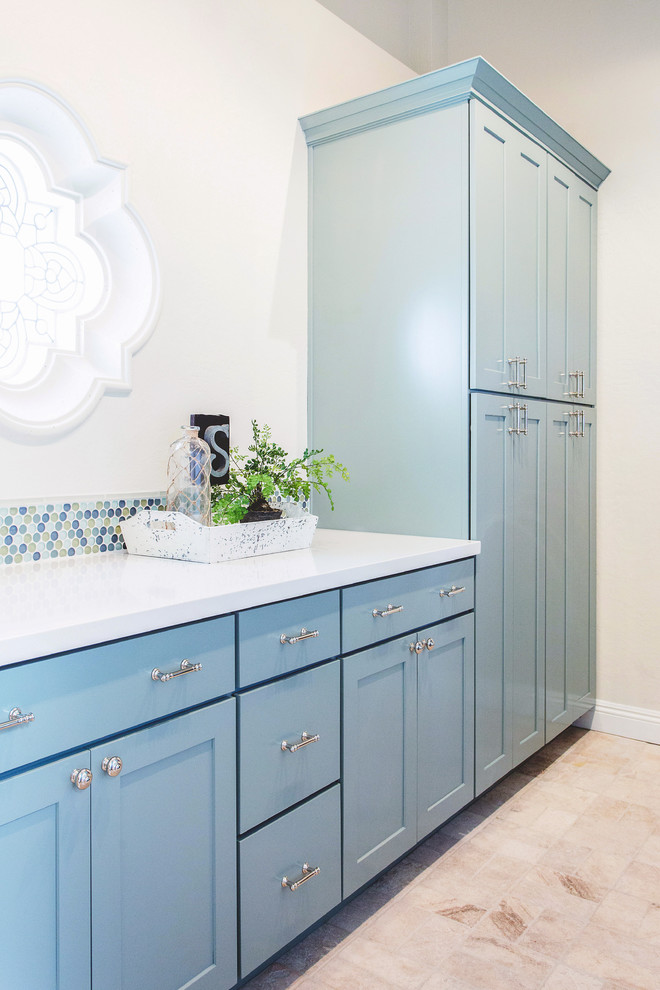 Esempio di una grande sala lavanderia mediterranea con lavello sottopiano, ante in stile shaker, ante blu, top in quarzo composito, pareti bianche, pavimento in travertino e lavatrice e asciugatrice affiancate