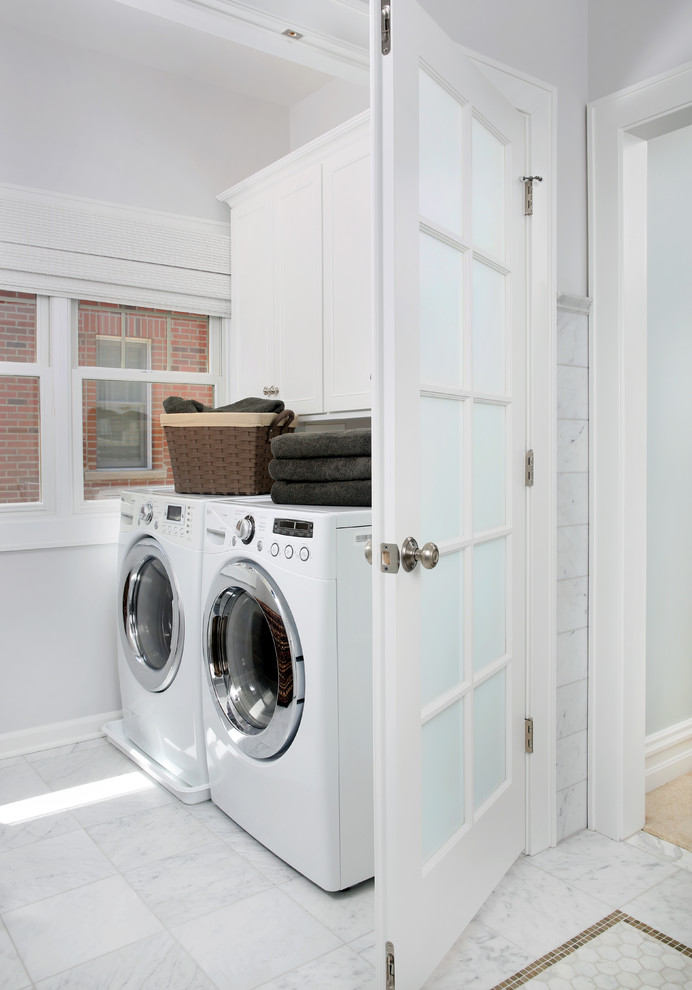 Immagine di una piccola lavanderia multiuso chic con ante con riquadro incassato, ante bianche, pareti grigie e lavatrice e asciugatrice affiancate