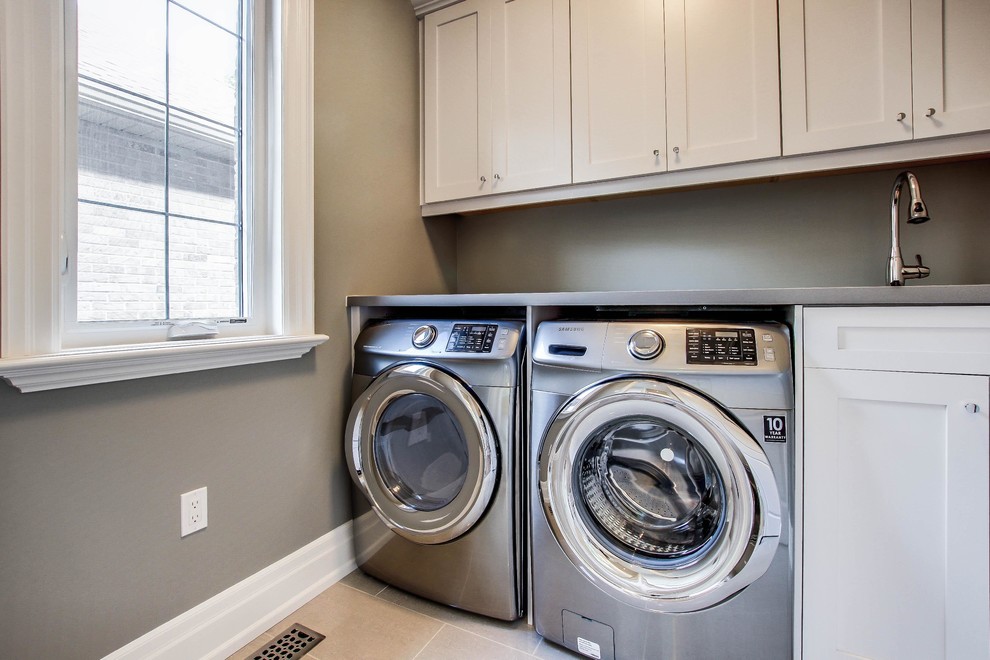 Design ideas for a medium sized traditional single-wall separated utility room in Toronto with a submerged sink, shaker cabinets, white cabinets, zinc worktops, beige walls, porcelain flooring and a side by side washer and dryer.