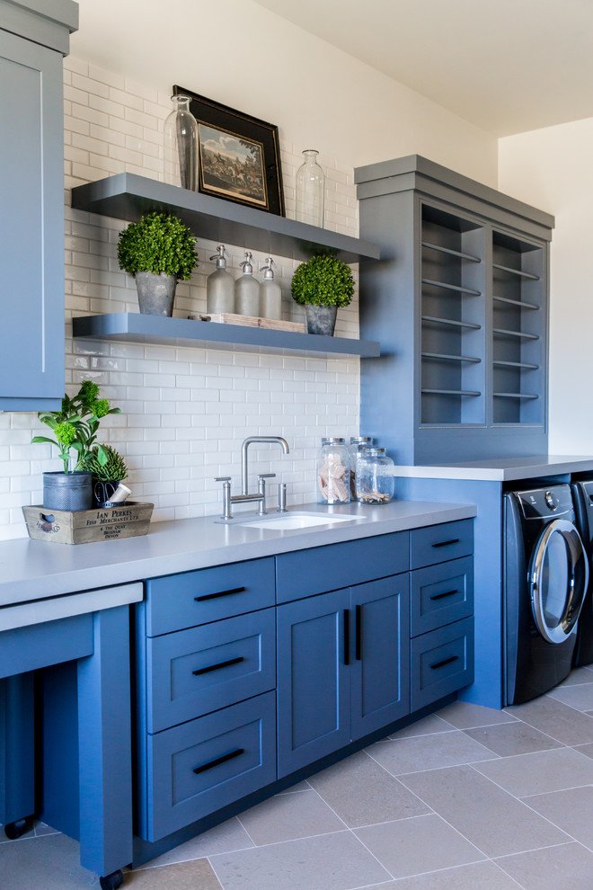 Inspiration for a large craftsman l-shaped limestone floor and gray floor utility room remodel in Salt Lake City with a drop-in sink, shaker cabinets, blue cabinets, quartz countertops, white walls, a side-by-side washer/dryer and gray countertops