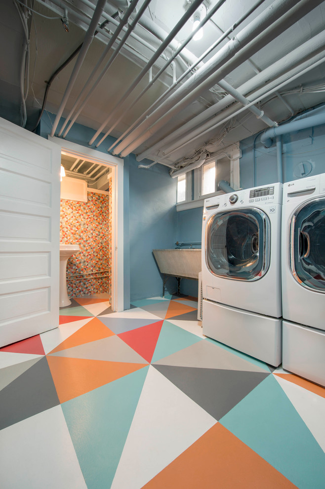 Exempel på en stor modern tvättstuga enbart för tvätt, med en rustik diskho, blå väggar, en tvättmaskin och torktumlare bredvid varandra och betonggolv