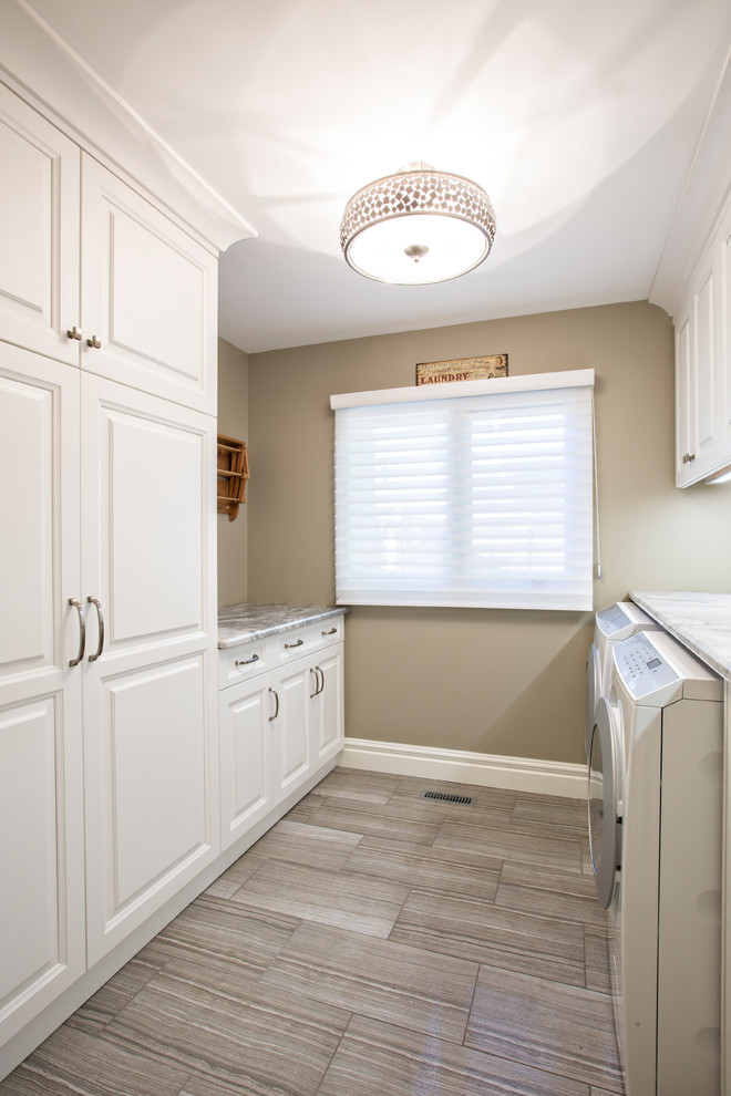 Idee per una sala lavanderia chic di medie dimensioni con ante bianche, top in marmo e lavatrice e asciugatrice affiancate