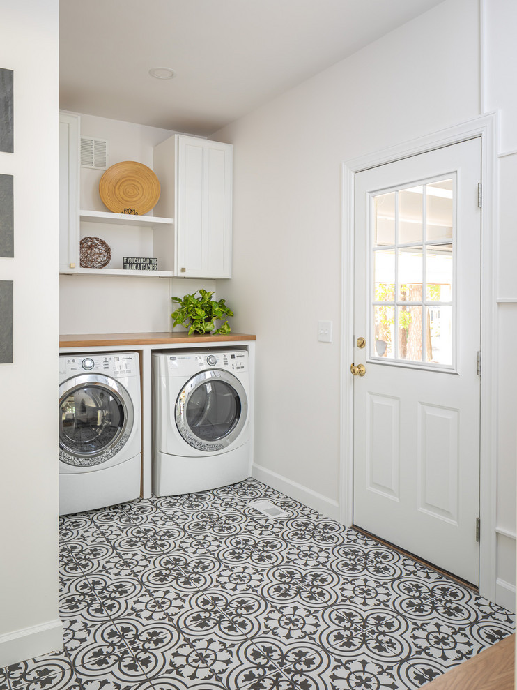 Medium sized rural utility room in Raleigh with a belfast sink, white cabinets, quartz worktops, white walls, porcelain flooring, a side by side washer and dryer, multi-coloured floors and brown worktops.