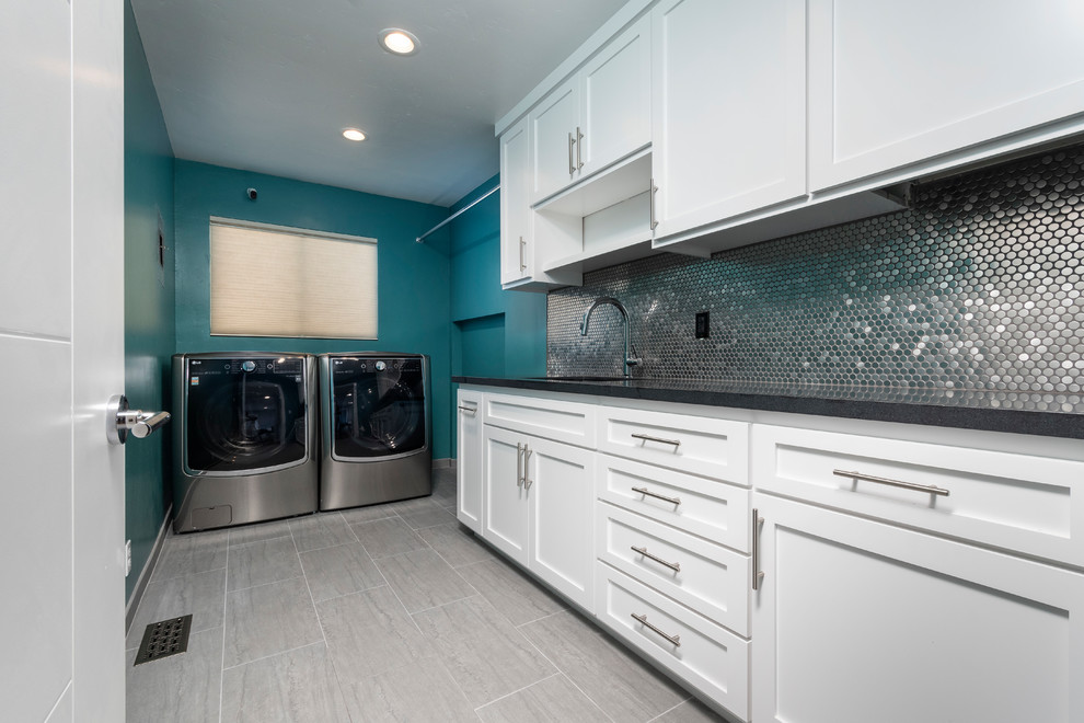 Große Moderne Waschküche in L-Form mit Unterbauwaschbecken, Schrankfronten im Shaker-Stil, weißen Schränken, Granit-Arbeitsplatte, grüner Wandfarbe, Porzellan-Bodenfliesen, Waschmaschine und Trockner nebeneinander, grauem Boden und schwarzer Arbeitsplatte in San Francisco