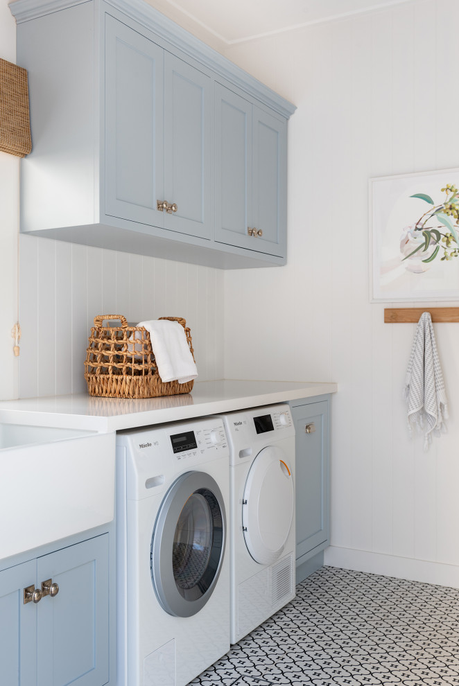 Klassischer Hauswirtschaftsraum mit Landhausspüle, Schrankfronten im Shaker-Stil, blauen Schränken, Waschmaschine und Trockner nebeneinander und weißer Arbeitsplatte in Perth