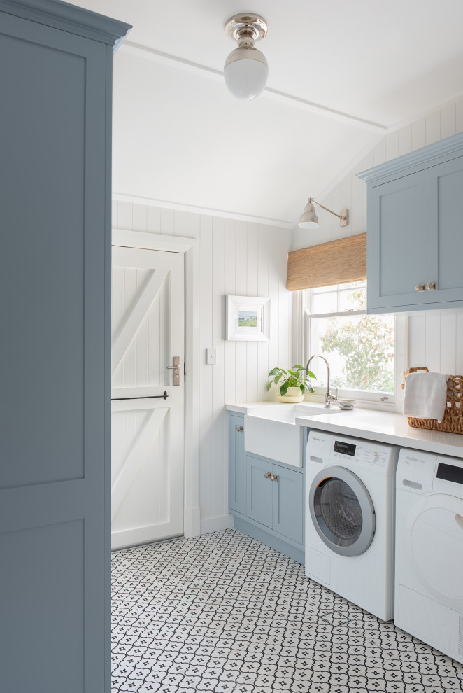 Design ideas for a medium sized classic galley utility room in Perth with a belfast sink, shaker cabinets, blue cabinets, a side by side washer and dryer, white worktops, white walls, multi-coloured floors and tongue and groove walls.