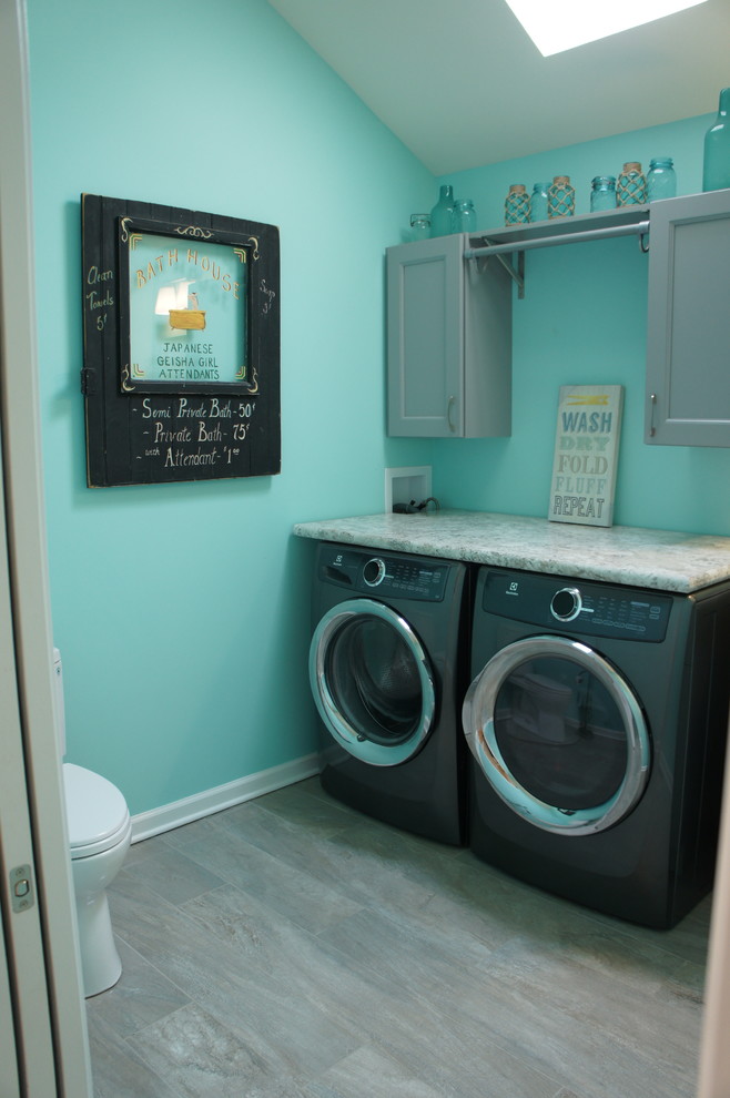 ニューヨークにあるお手頃価格の中くらいなトランジショナルスタイルのおしゃれな家事室 (I型、ドロップインシンク、シェーカースタイル扉のキャビネット、グレーのキャビネット、ラミネートカウンター、青い壁、セラミックタイルの床、左右配置の洗濯機・乾燥機) の写真