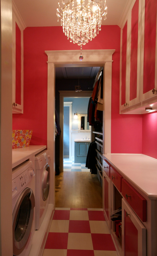 Foto de cuarto de lavado de galera romántico de tamaño medio con armarios estilo shaker, puertas de armario blancas, encimera de madera, paredes rosas, suelo de madera clara y lavadora y secadora juntas