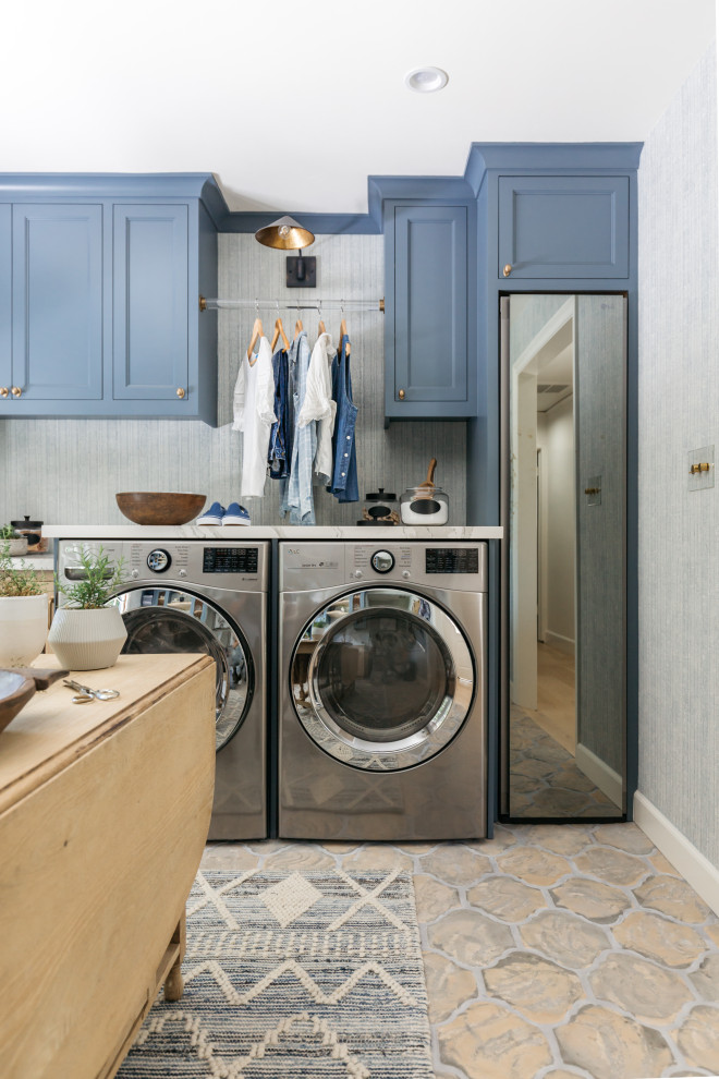Esempio di una lavanderia multiuso minimal di medie dimensioni con lavello sottopiano, ante in stile shaker, ante blu, top in marmo, pareti blu, lavatrice e asciugatrice affiancate e top bianco