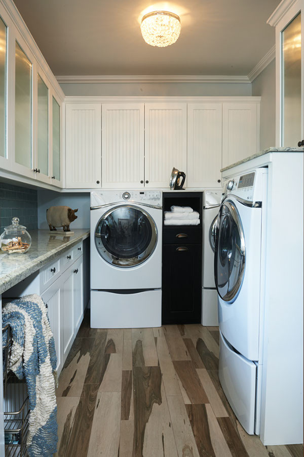 ロサンゼルスにあるお手頃価格の中くらいなエクレクティックスタイルのおしゃれな家事室 (L型、シェーカースタイル扉のキャビネット、白いキャビネット、珪岩カウンター、白い壁、無垢フローリング、左右配置の洗濯機・乾燥機) の写真