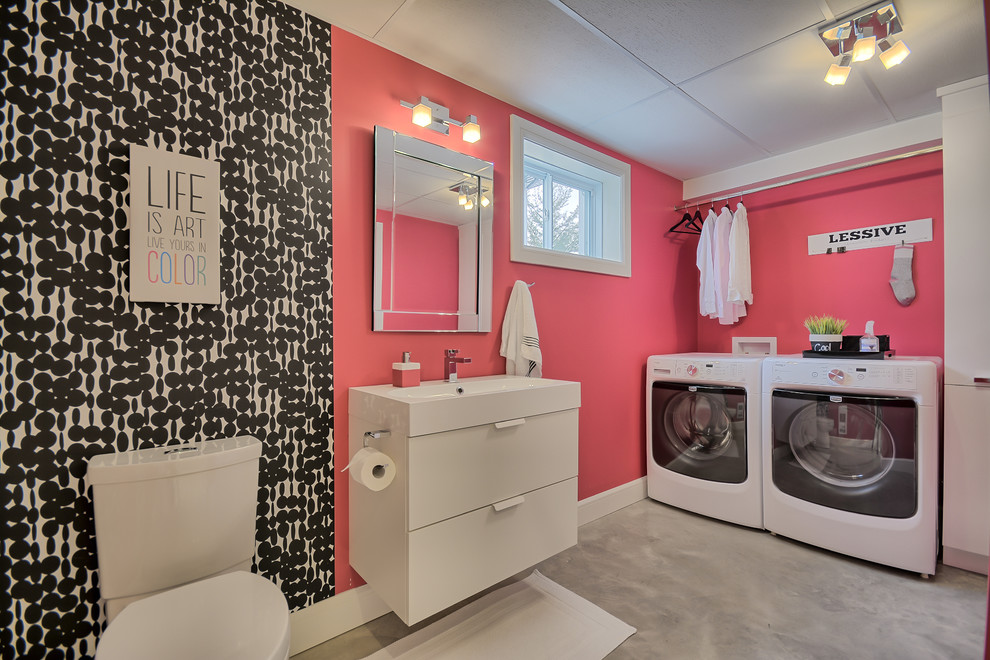 Inspiration för mellanstora moderna linjära grovkök, med rosa väggar, betonggolv och en tvättmaskin och torktumlare bredvid varandra
