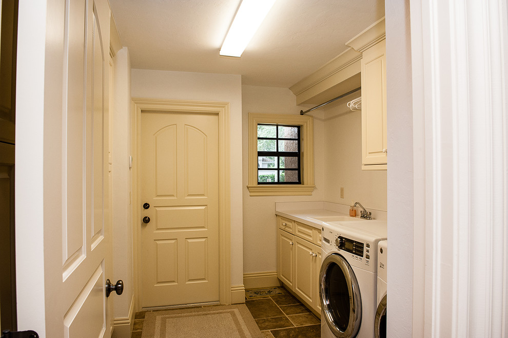 Foto di una lavanderia multiuso chic di medie dimensioni con lavello da incasso, ante beige, pareti beige, lavatrice e asciugatrice affiancate e ante con bugna sagomata
