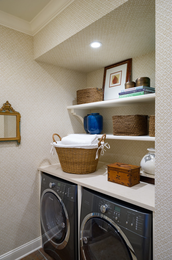 Modelo de lavadero clásico renovado pequeño con encimera de cuarzo compacto, paredes beige, suelo de baldosas de porcelana y lavadora y secadora juntas