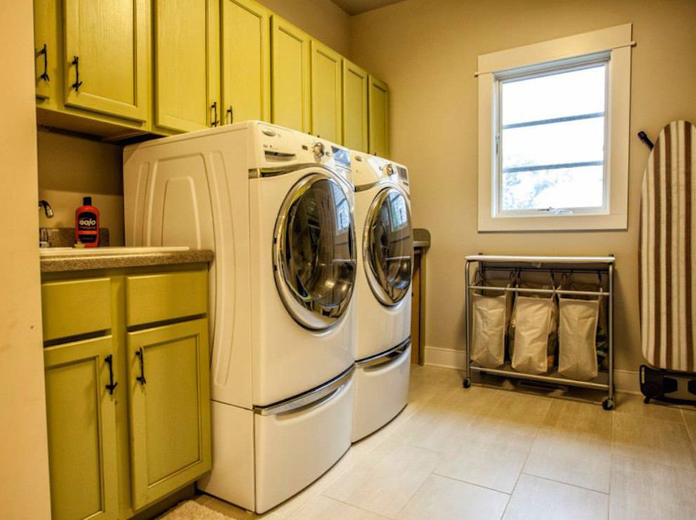Foto di una lavanderia multiuso classica con ante con riquadro incassato, ante verdi, pareti beige, parquet chiaro e lavatrice e asciugatrice affiancate