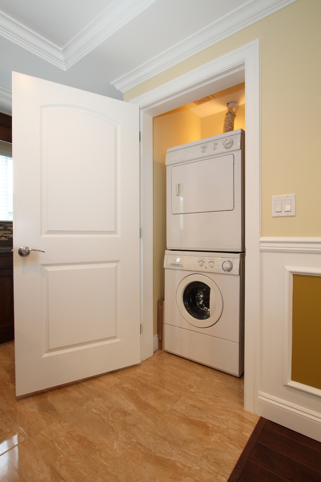 Idee per un piccolo ripostiglio-lavanderia tradizionale con pareti beige, pavimento con piastrelle in ceramica e lavatrice e asciugatrice a colonna