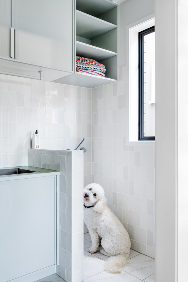 Réalisation d'une grande buanderie linéaire tradition en bois clair avec un évier posé, un plan de travail en cuivre, une crédence blanche, une crédence en carreau de porcelaine, un mur blanc, parquet foncé, des machines superposées, un sol marron et un plan de travail jaune.