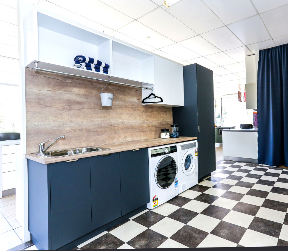 Immagine di una piccola sala lavanderia design con lavello da incasso, ante lisce, ante grigie, top in laminato, pareti marroni, pavimento in vinile, lavatrice e asciugatrice affiancate e top marrone