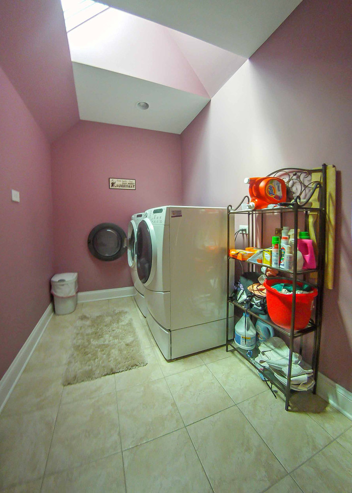 Idéer för en stor klassisk linjär tvättstuga enbart för tvätt, med rosa väggar, klinkergolv i keramik, en tvättmaskin och torktumlare bredvid varandra, beiget golv, öppna hyllor och svarta skåp