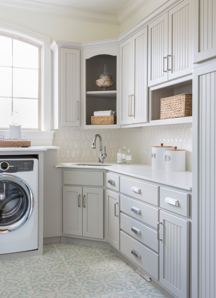 Ejemplo de lavadero tradicional con fregadero bajoencimera, armarios con paneles empotrados, puertas de armario grises, suelo multicolor y encimeras blancas