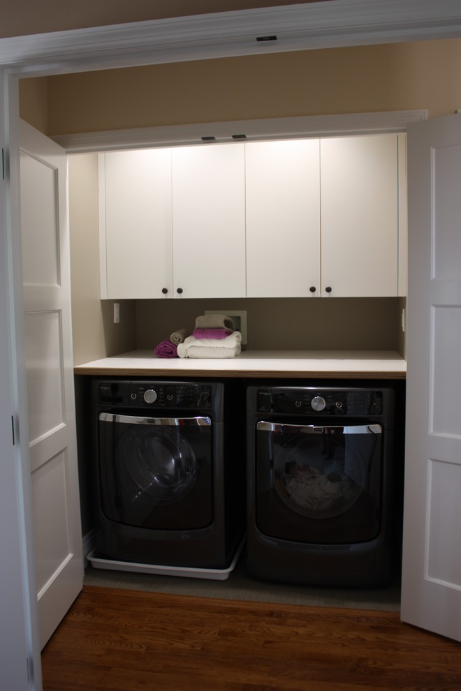 Transitional single-wall porcelain tile and gray floor dedicated laundry room photo in San Diego with flat-panel cabinets, white cabinets, laminate countertops, beige walls and a side-by-side washer/dryer