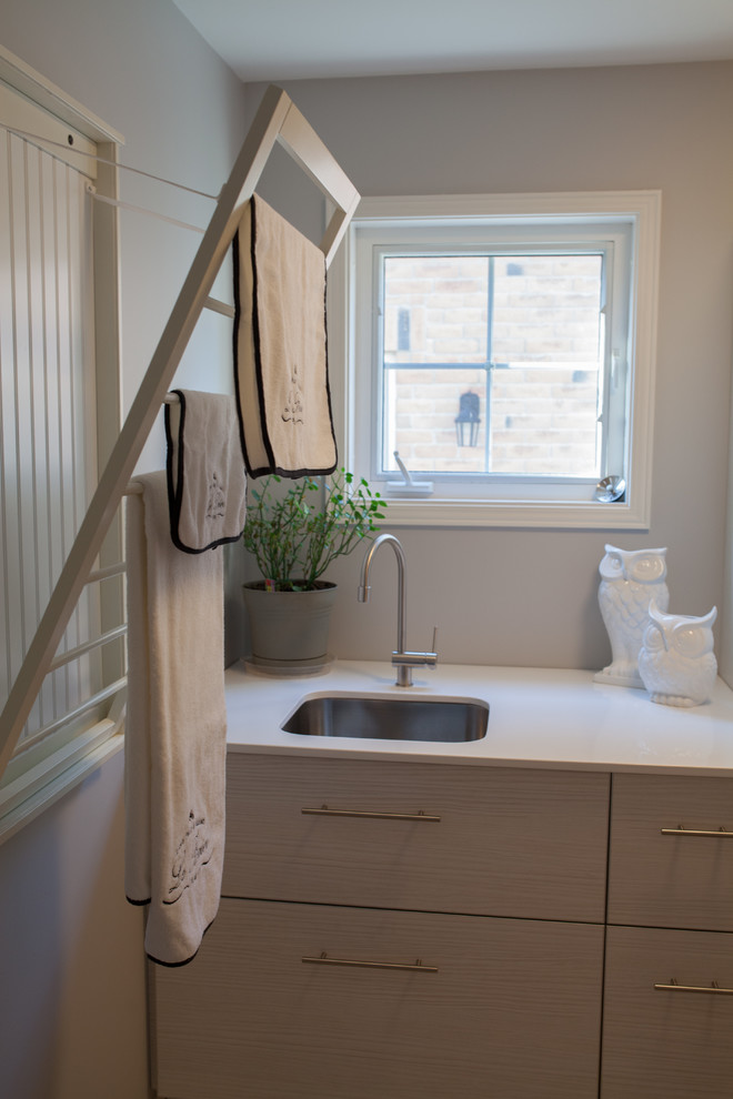 Example of a transitional laundry room design in Toronto with an undermount sink and flat-panel cabinets