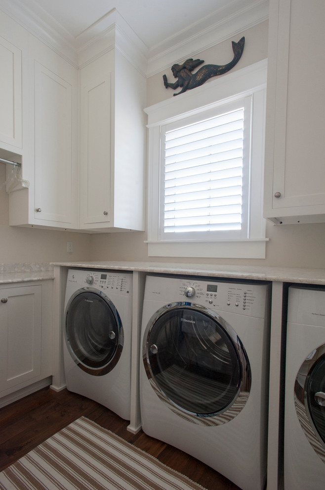 Mid-sized beach style u-shaped dark wood floor dedicated laundry room photo in Jacksonville with shaker cabinets, white cabinets, quartz countertops, beige walls and a side-by-side washer/dryer