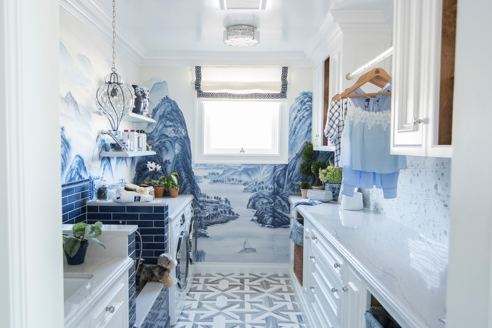 Idee per una lavanderia multiuso classica con lavello sottopiano, ante con riquadro incassato, ante bianche, pareti blu, lavatrice e asciugatrice affiancate e pavimento bianco