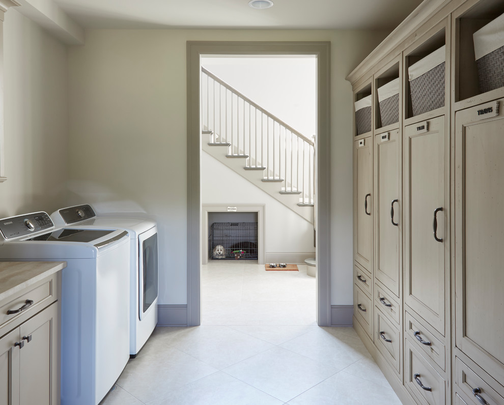 Foto på en mellanstor vintage beige parallell liten tvättstuga, med luckor med upphöjd panel, beige skåp, marmorbänkskiva, vita väggar, klinkergolv i keramik, en tvättmaskin och torktumlare bredvid varandra och vitt golv