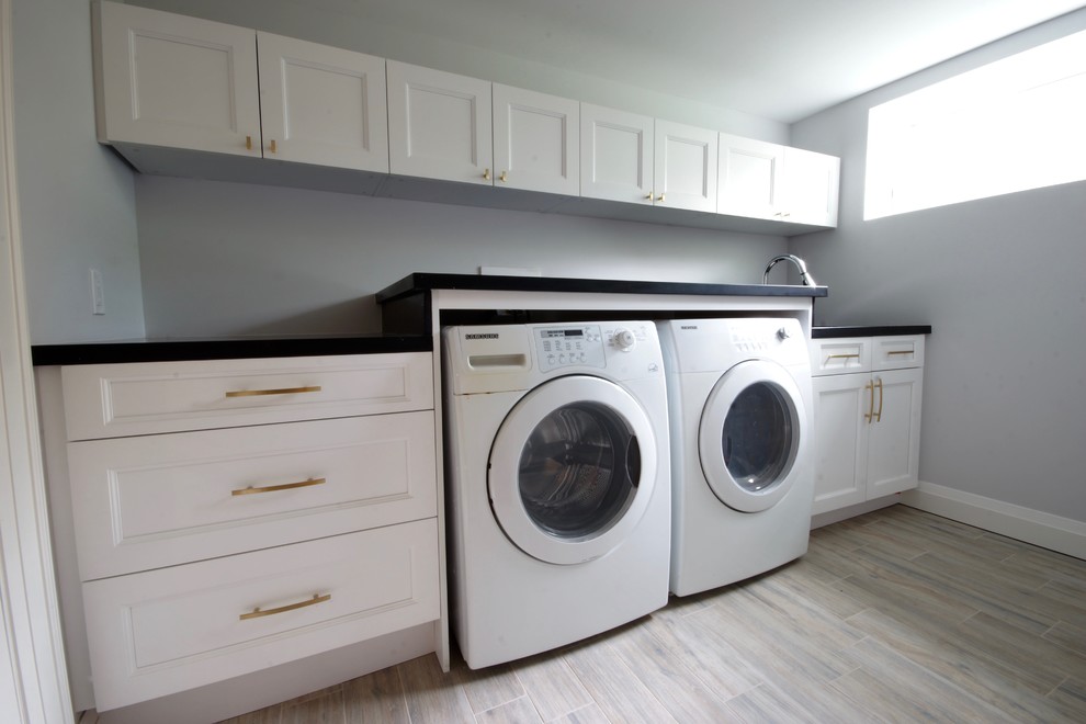Inspiration for a mid-sized contemporary single-wall porcelain tile and beige floor dedicated laundry room remodel in Toronto with an undermount sink, shaker cabinets, white cabinets, quartz countertops, gray walls and a side-by-side washer/dryer
