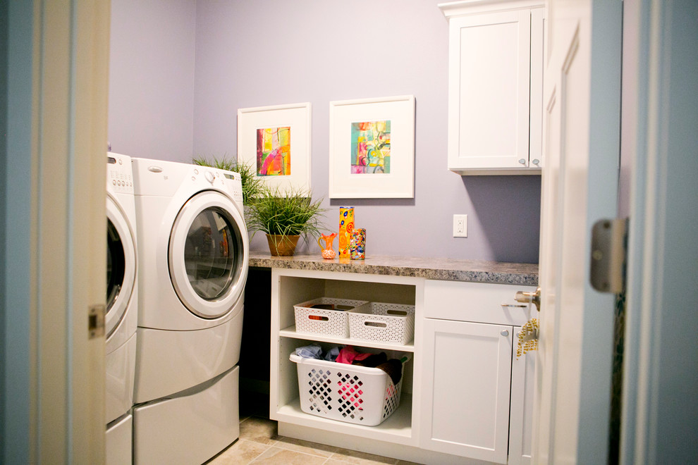 Foto på en mellanstor vintage l-formad tvättstuga enbart för tvätt, med skåp i shakerstil, vita skåp, laminatbänkskiva, lila väggar, klinkergolv i porslin och en tvättmaskin och torktumlare bredvid varandra