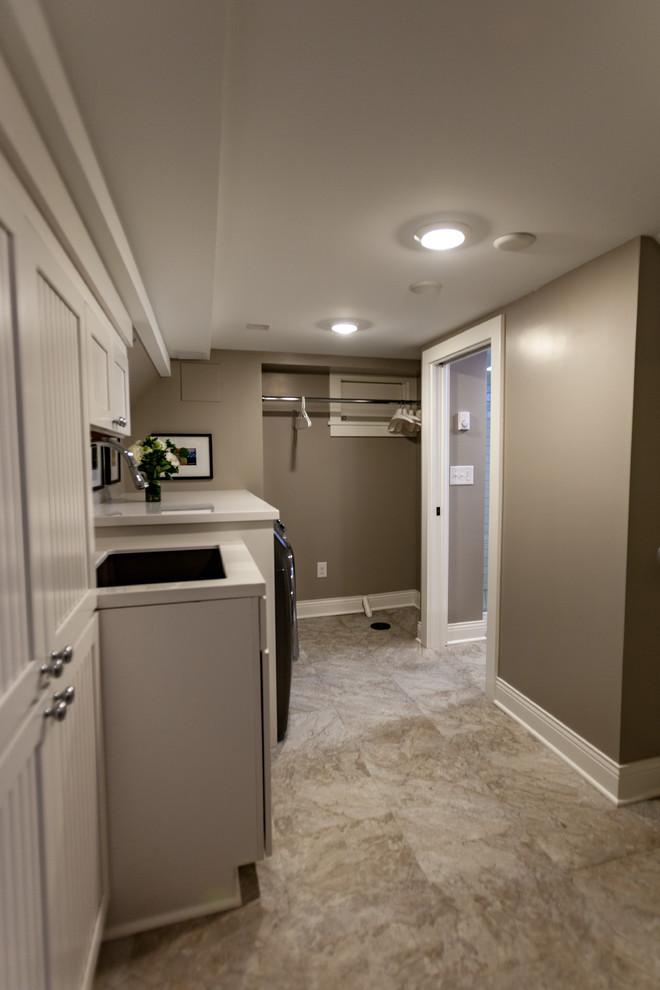 Large elegant single-wall vinyl floor and beige floor dedicated laundry room photo in Minneapolis with an undermount sink, beaded inset cabinets, white cabinets, marble countertops, beige walls, a side-by-side washer/dryer and white countertops