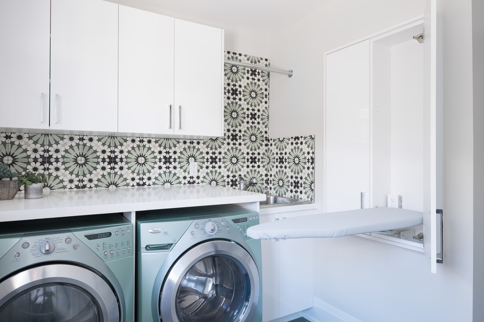 Modelo de cuarto de lavado contemporáneo con armarios con paneles lisos, puertas de armario blancas, encimera de acrílico, paredes multicolor y encimeras blancas