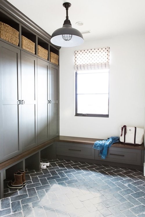 Exempel på en mellanstor eklektisk tvättstuga, med träbänkskiva, vita väggar, tegelgolv, en tvättmaskin och torktumlare bredvid varandra och svart golv