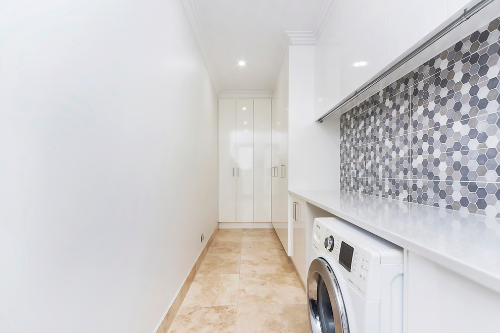 Traditional single-wall utility room in Adelaide with flat-panel cabinets, white cabinets, engineered stone countertops, white walls and a side by side washer and dryer.