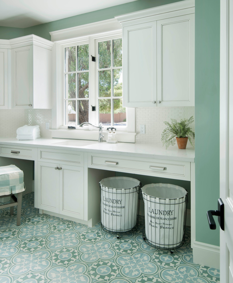 Foto di una sala lavanderia con ante bianche, top in quarzo composito, pareti verdi, lavatrice e asciugatrice affiancate, top bianco e ante con riquadro incassato