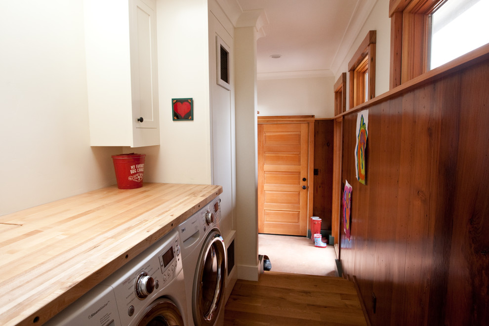 Example of a classic laundry room design in San Francisco with wood countertops and beige countertops