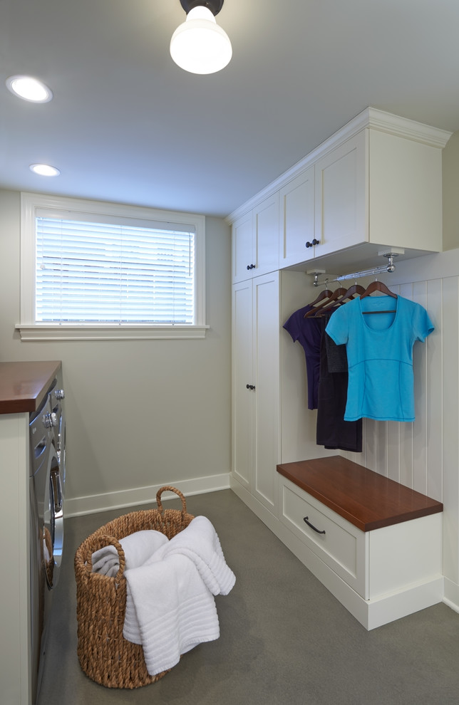 Example of a classic galley concrete floor laundry room design in Seattle with shaker cabinets, white cabinets, white walls, a side-by-side washer/dryer and wood countertops