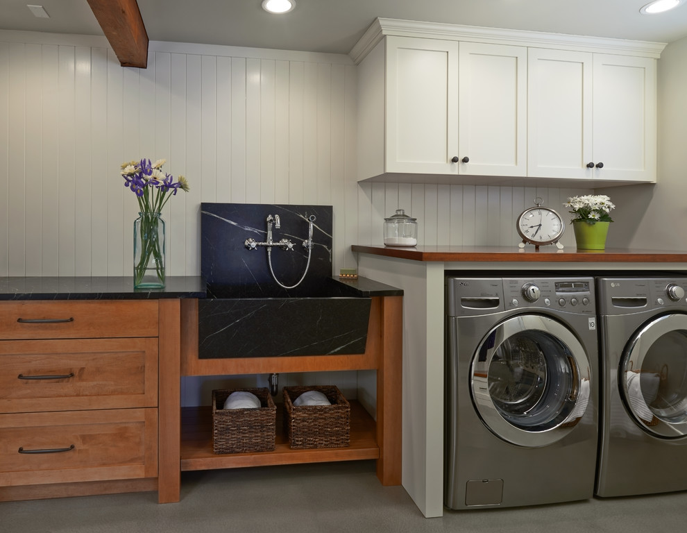 Design ideas for a traditional galley utility room in Seattle with a belfast sink, shaker cabinets, white cabinets, soapstone worktops, white walls, concrete flooring and a side by side washer and dryer.