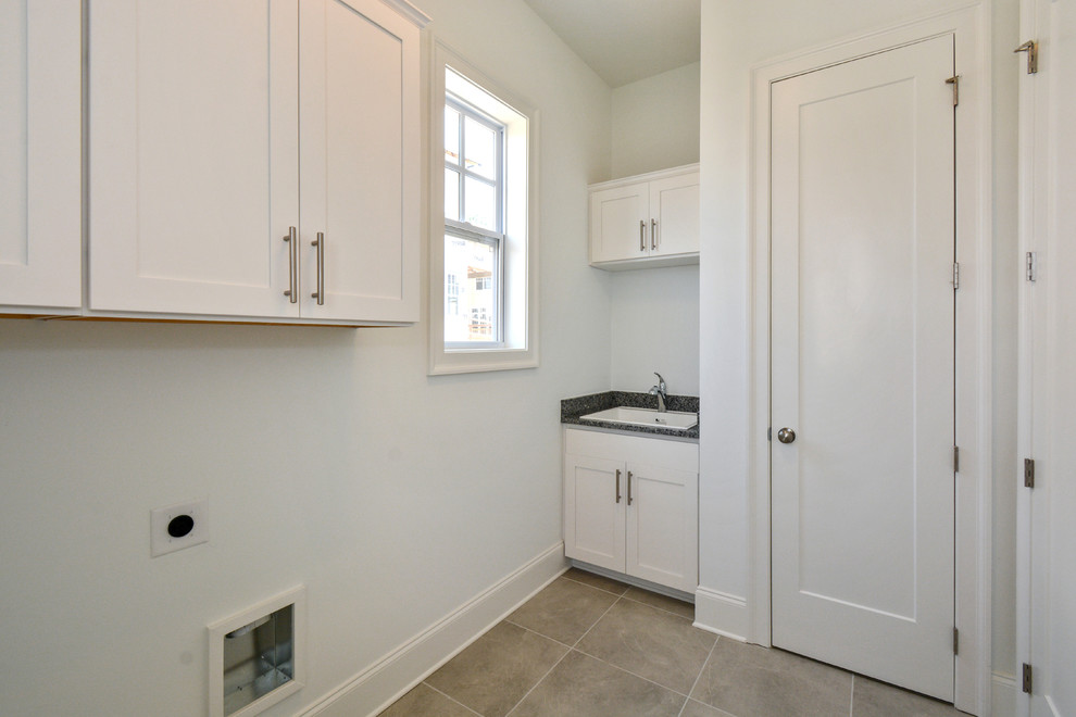 Large modern separated utility room in Atlanta with shaker cabinets, white cabinets and a side by side washer and dryer.