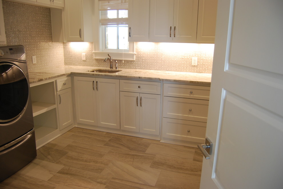 Large classic l-shaped separated utility room in Dallas with a submerged sink, shaker cabinets, white cabinets, marble worktops, beige walls, porcelain flooring, a side by side washer and dryer and beige floors.