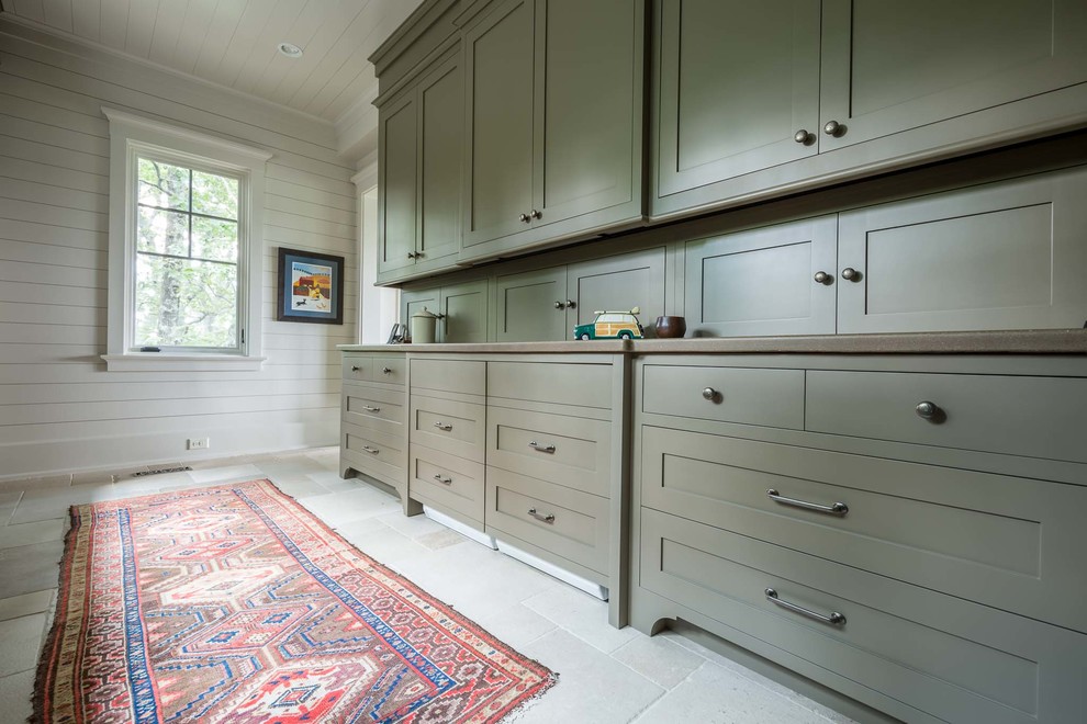 Utility room - huge transitional galley slate floor utility room idea in Nashville with an integrated sink, flat-panel cabinets, green cabinets, white walls and a concealed washer/dryer