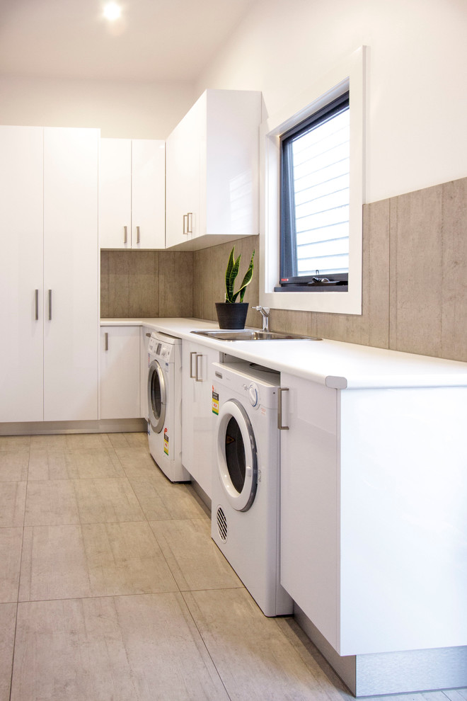 Idee per una sala lavanderia minimal di medie dimensioni con lavatoio, ante bianche, top in quarzo composito, pareti bianche e pavimento con piastrelle in ceramica