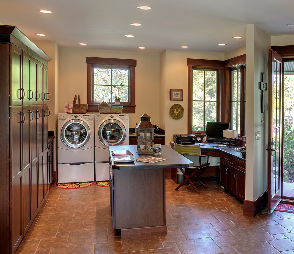 シカゴにあるカントリー風のおしゃれな家事室 (濃色木目調キャビネット、左右配置の洗濯機・乾燥機) の写真